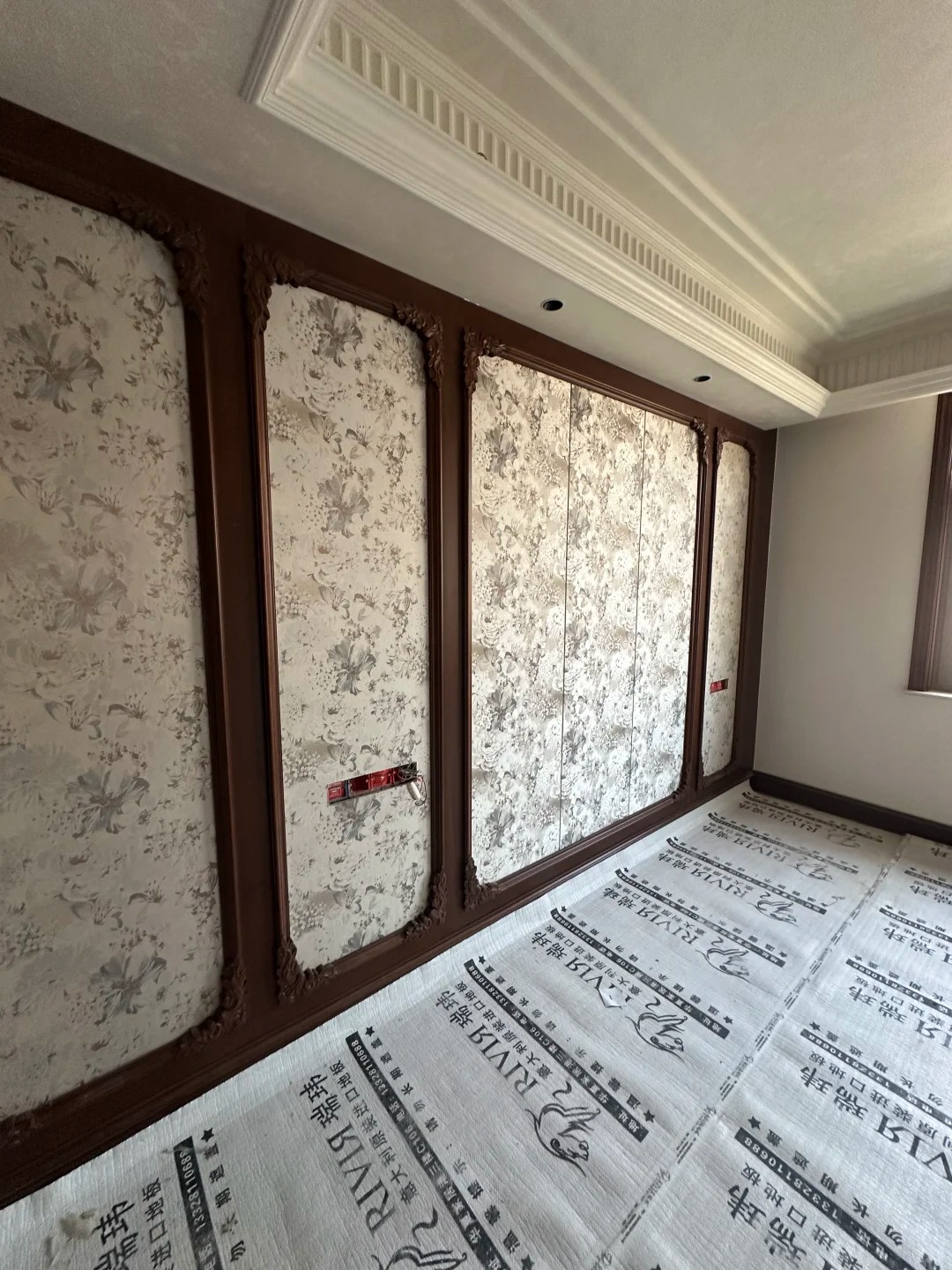Wall panel installation site with protective floor covering
